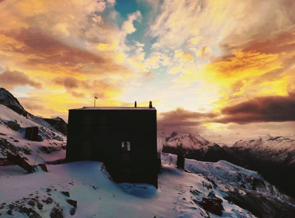 Die Rothornhütte im Zermatt-Gebirge bei Sonnenaufgang in Mitten von Schnee und Stein.