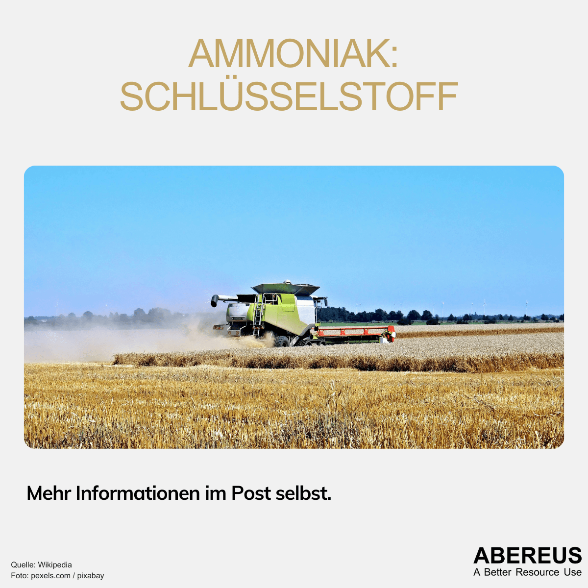 Auf dem Foto ist ein Mähdrescher unter blauem Himmel auf einem Feld unterwegs und verrichtet seine Arbeit. Im Hintergrund erkennt man Wälder und Windkraftanlagen.