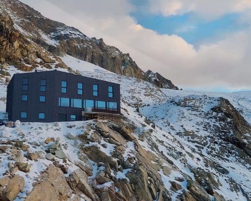 Auf dem Foto ist ein Haus in einem Berg mit Schnee.